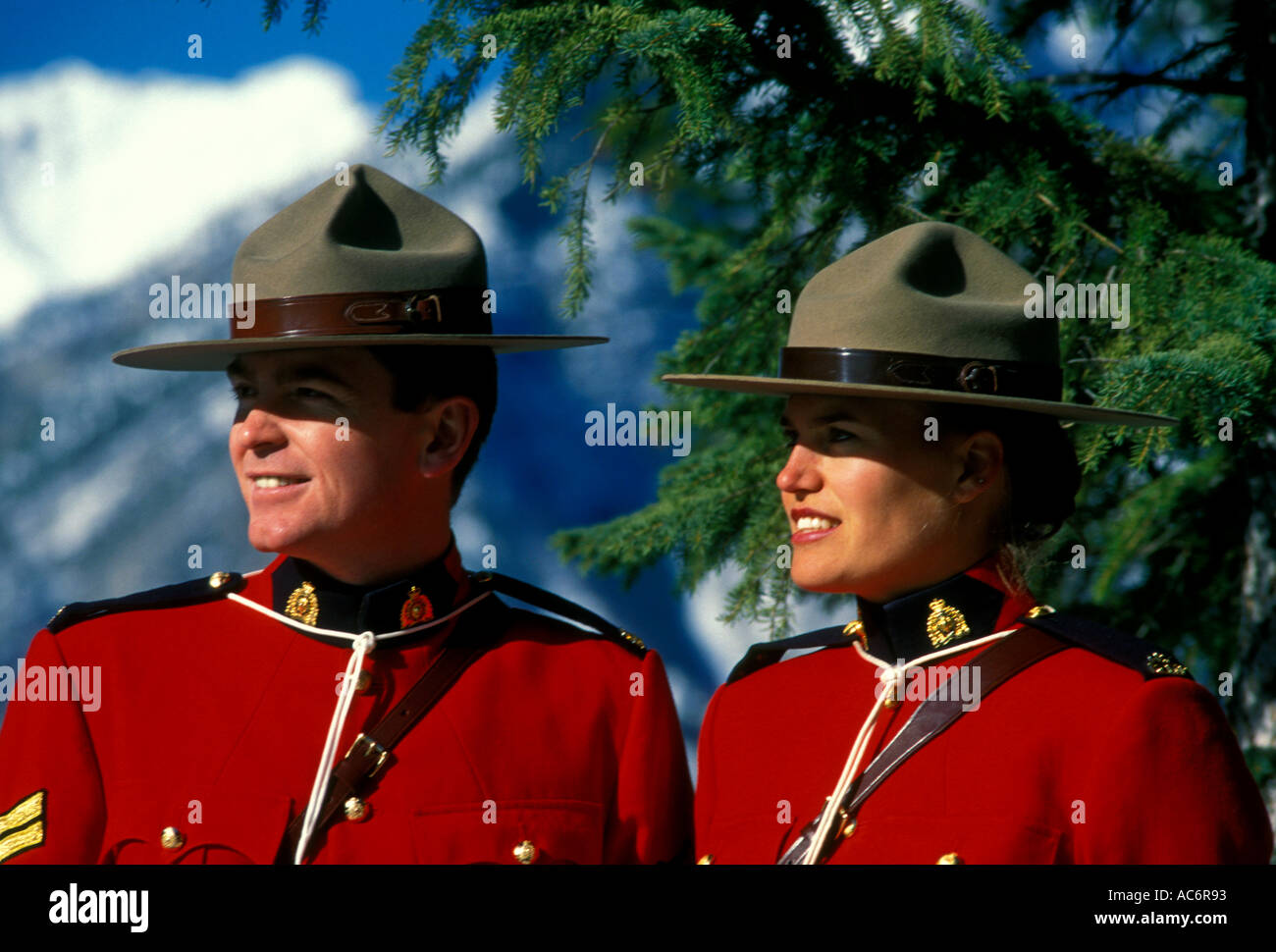 adult man and woman male and female Royal Canadian Mounted Police RCMP aka Canadian Mounties on duty in Canadian Rockies in Banff in Alberta Canada Stock Photo