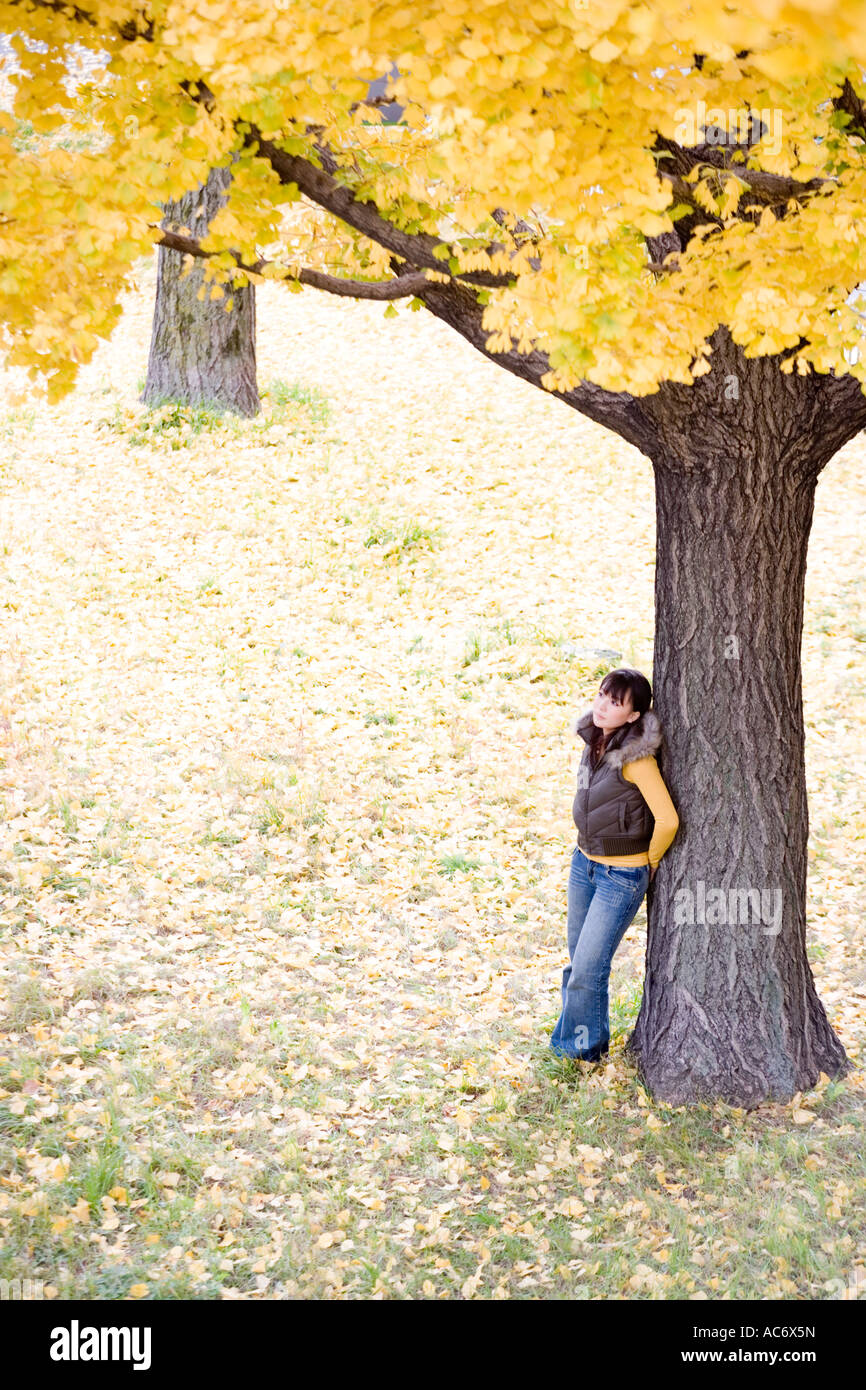 Young woman standing under tree Stock Photo