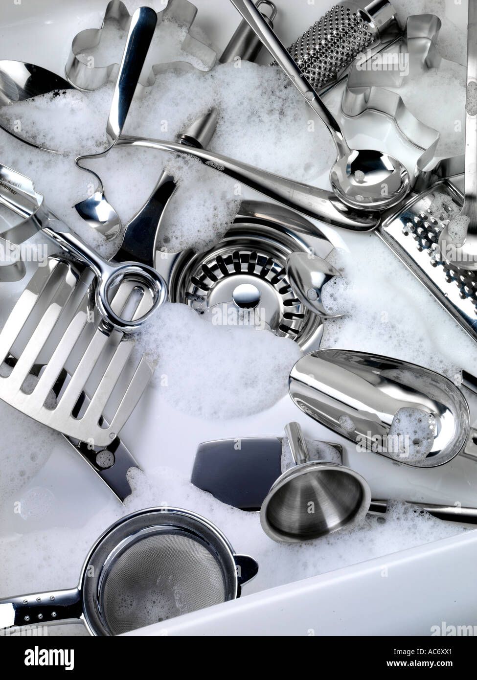 WASHING KITCHEN UTENSILS IN SINK Stock Photo