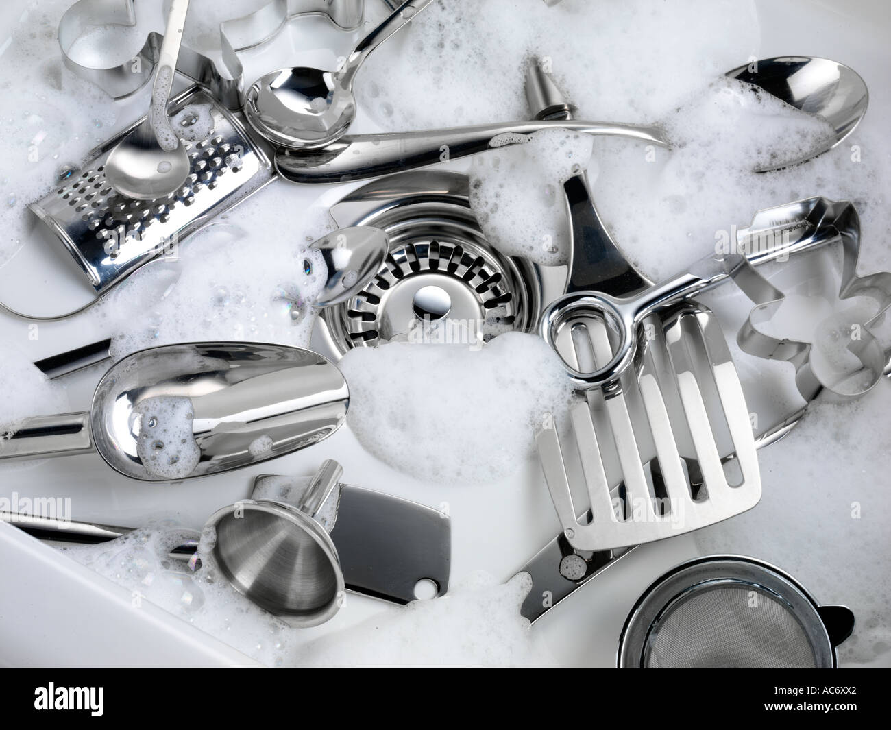 WASHING KITCHEN UTENSILS IN SINK Stock Photo