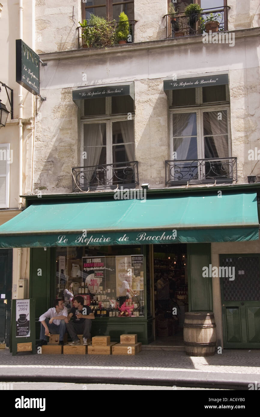 Two men eating lunch in front of Le Repaire de Bacchus wine shop on Rue Montorgueil in the Des Halles area of Paris France Stock Photo