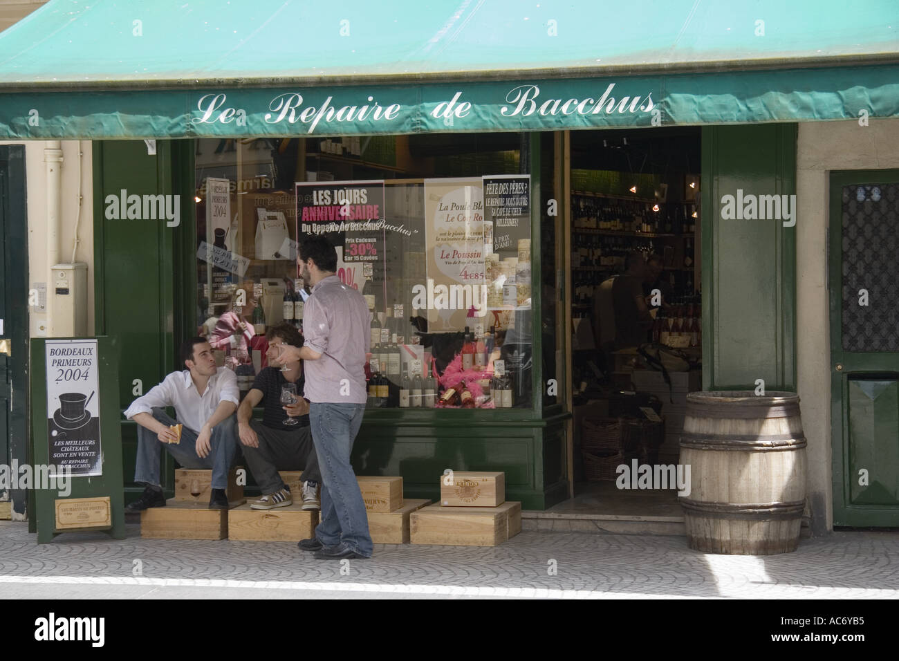 Three men eating lunch in front of Le Repaire de Bacchus wine shop on Rue Montorgueil in the Des Halles area of Paris France Stock Photo
