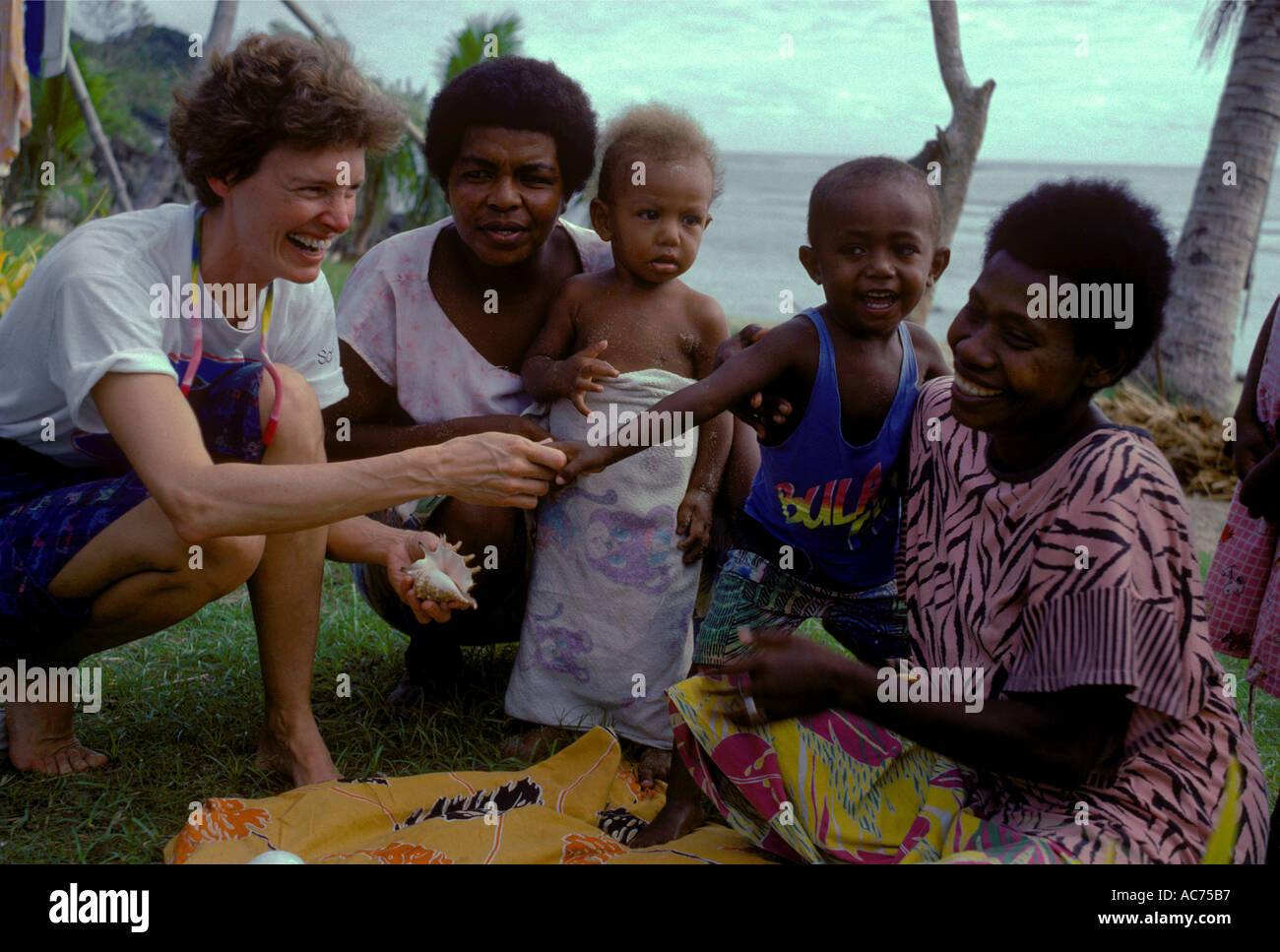 AMERICAN TOURIST shops for SEASHELLS and meets NATIVE VILLAGERS in the VILLAGE of NALAUWAKI YASAWA ISLANDS FIJI Stock Photo