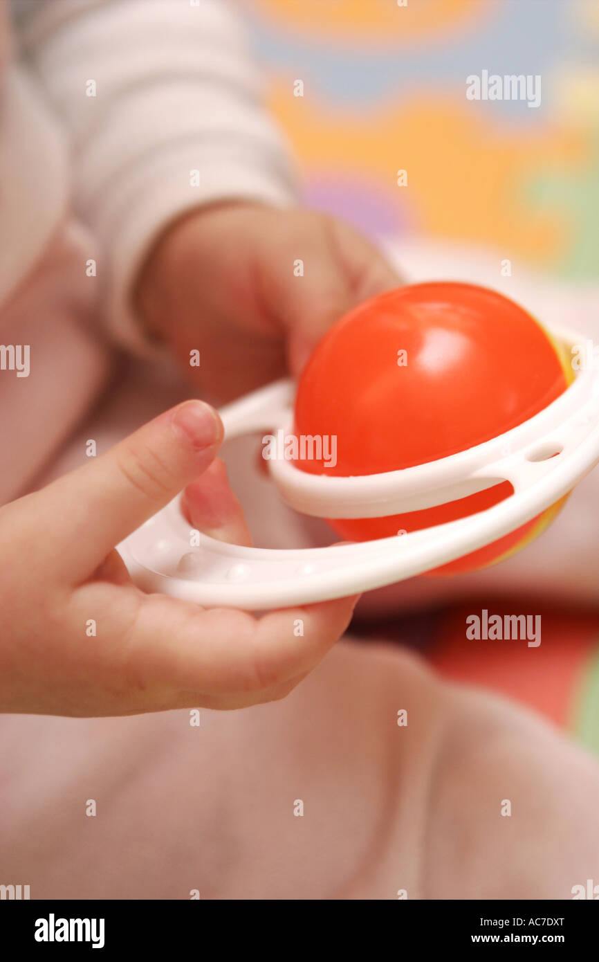 Rattle in baby hands Stock Photo Alamy