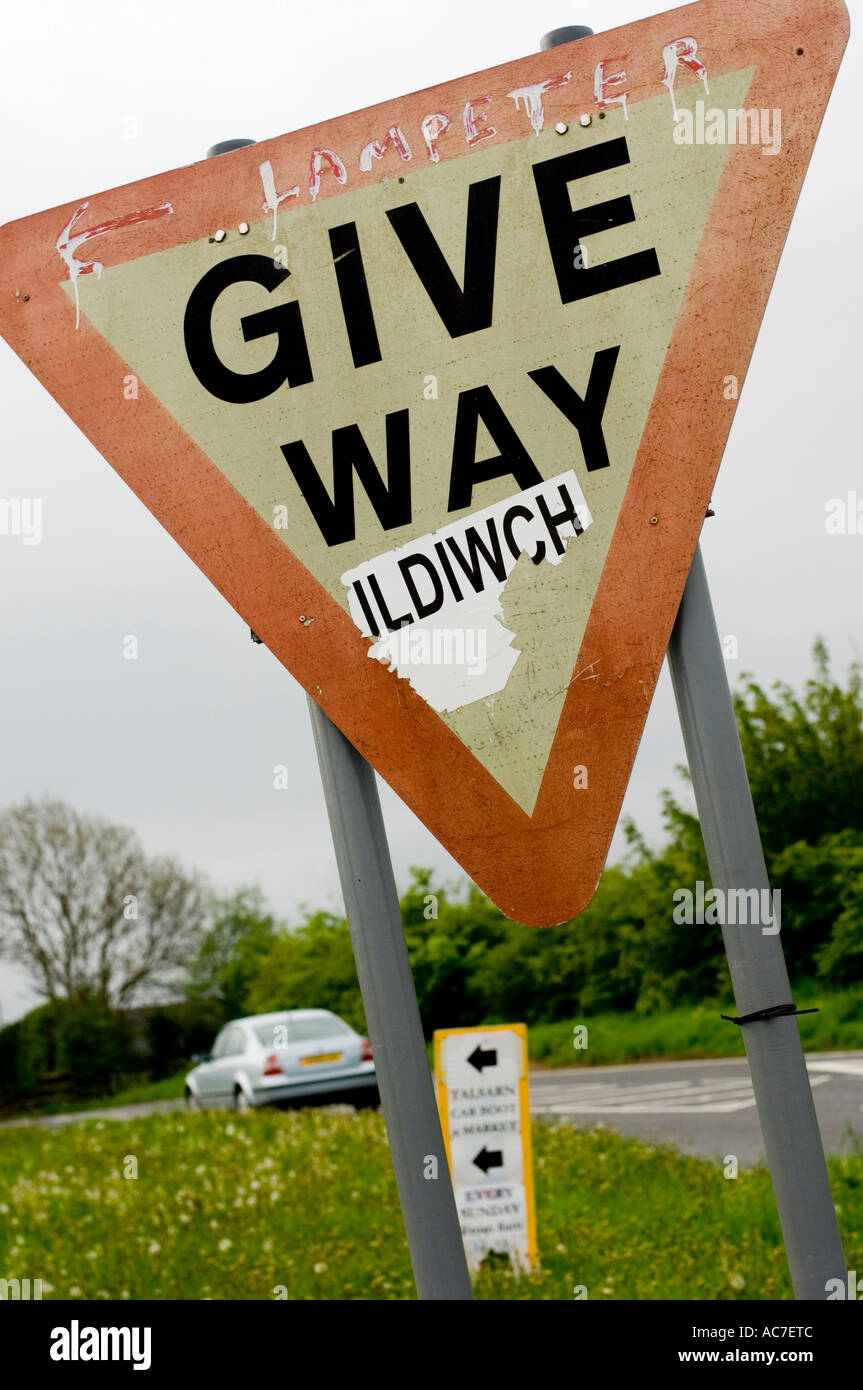 Give Way road sign with welsh translation pasted over it in protest of its monolingual nature. Near Lampeter, Wales UK Stock Photo