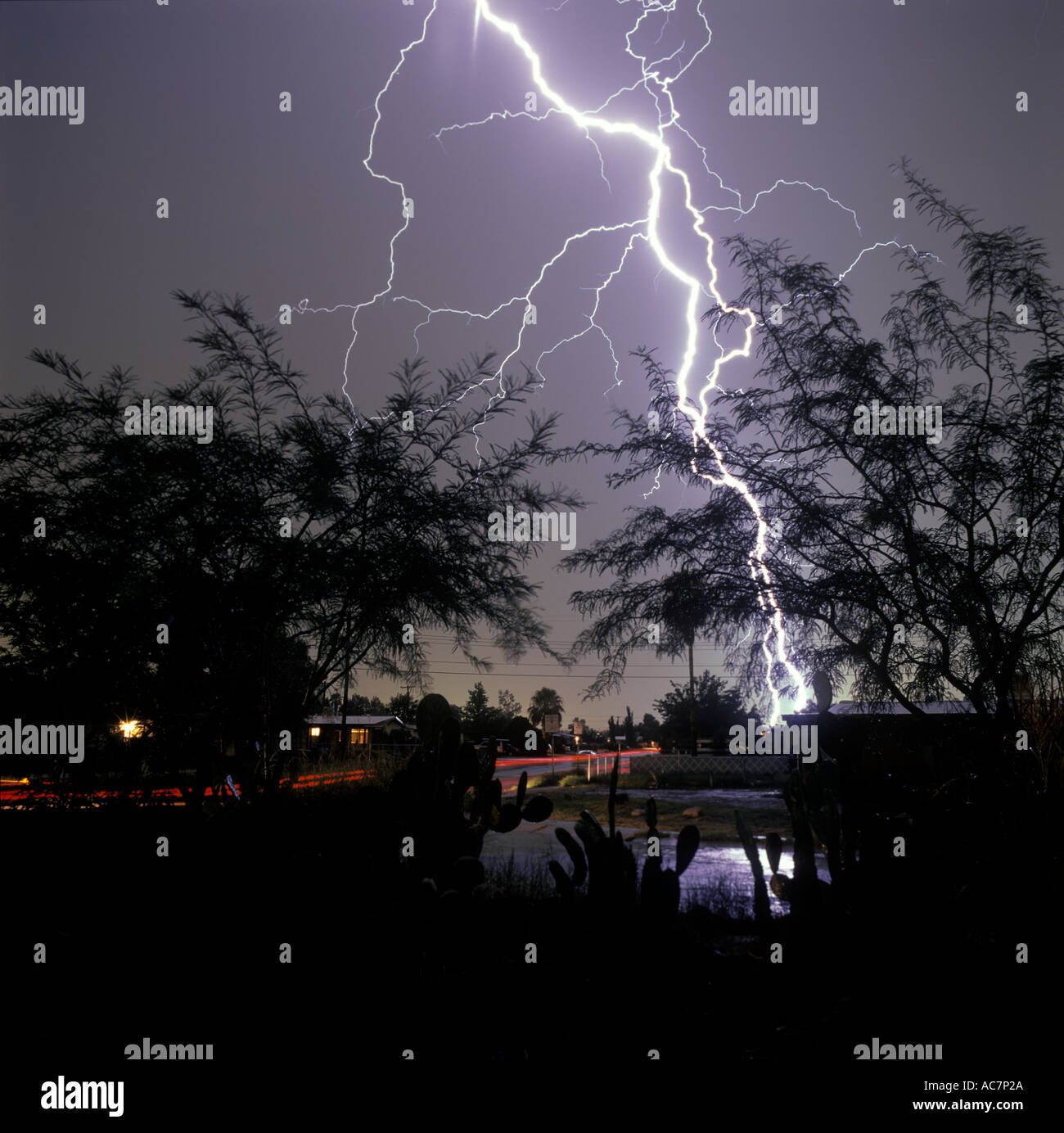 Lightning strike from front yard of home looking down neighborhood street in Tucson, Arizona, USA. Stock Photo