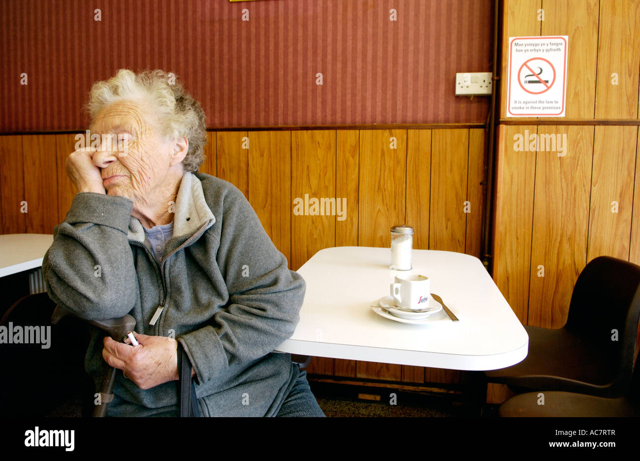 Elderly lady clutching cigarette  as No Smoking ban comes into force in cafe Newbridge South Wales UK Stock Photo