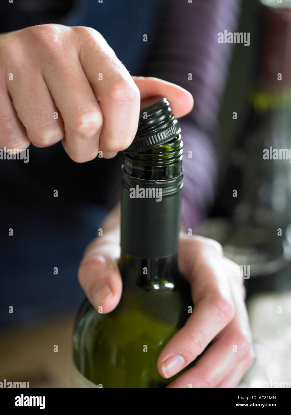 person opening a screwtop bottle of wine Stock Photo Alamy
