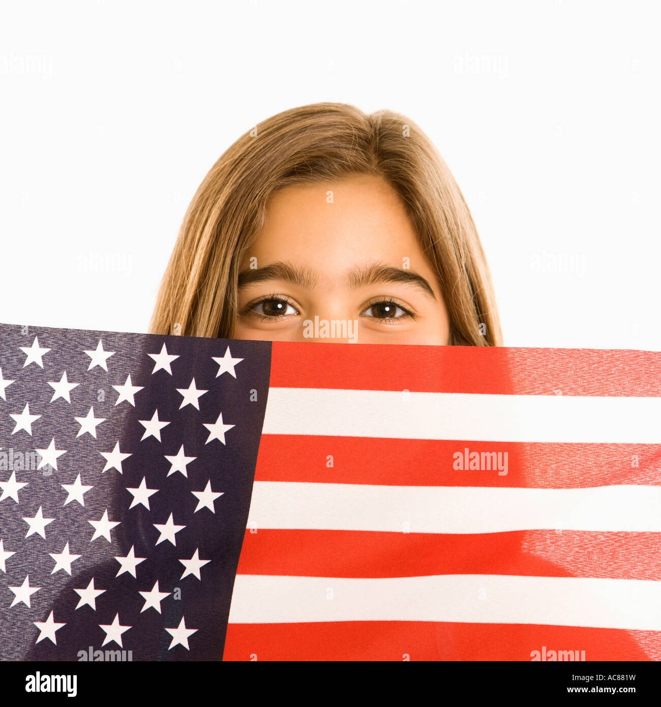 Girl peeking over American flag against white background Stock Photo ...