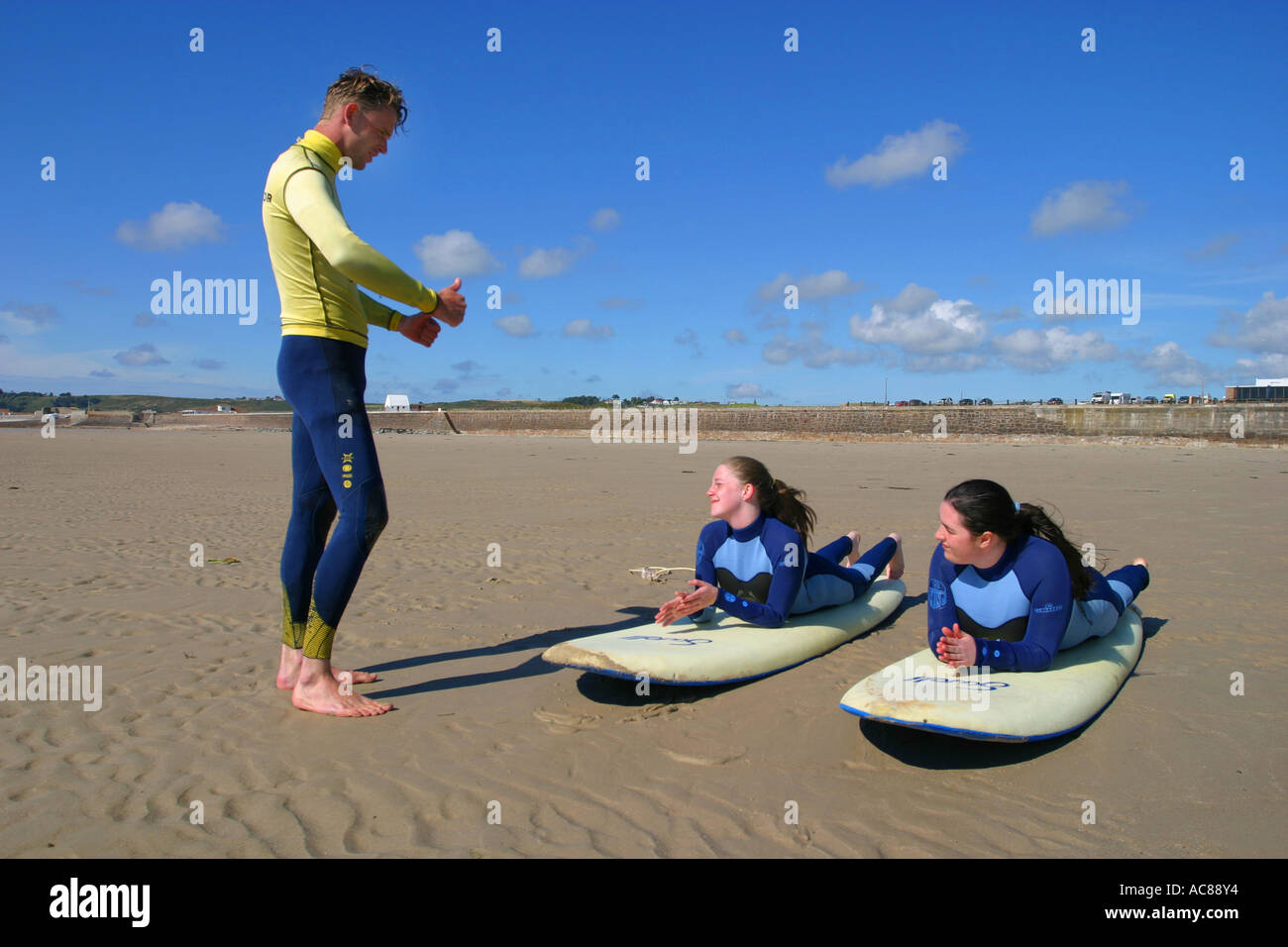 Two young teenage girls first surfing lesson on St Ouen's Beach Jersey