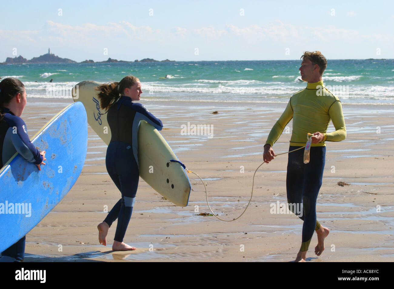 Two young teenage girls first surfing lesson on St Ouen's Beach Jersey