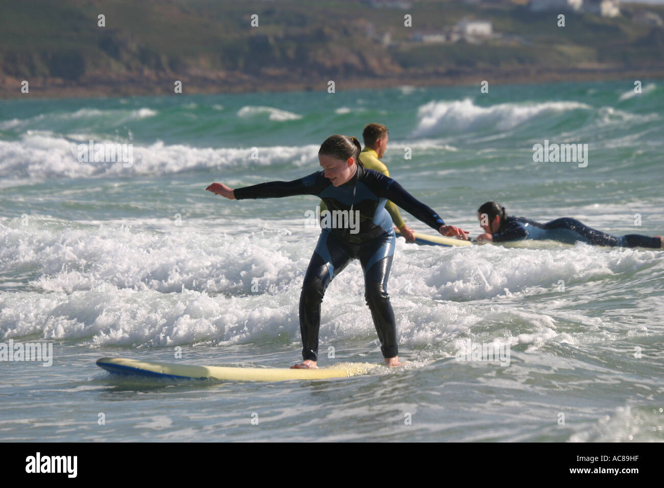 Two young teenage girls first surfing lesson on St Ouen's Beach Jersey
