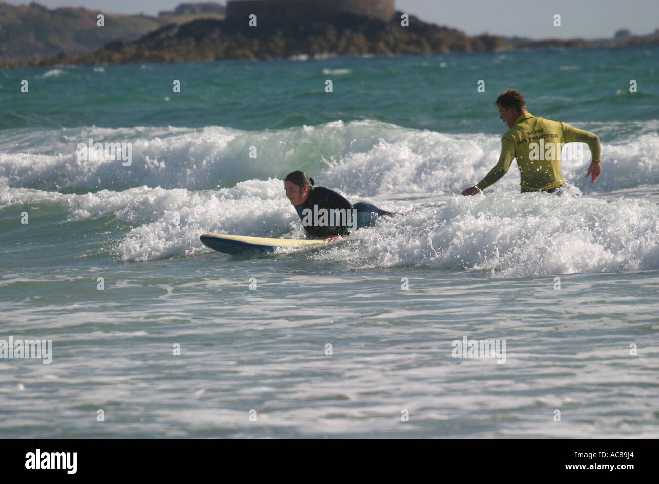 Two young teenage girls first surfing lesson on St Ouen's Beach Jersey