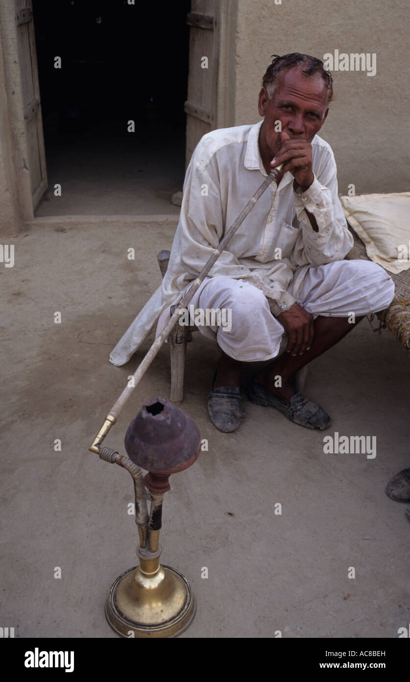 Pakistan Northwest Frontier Province Poor farmer smoking a hookah