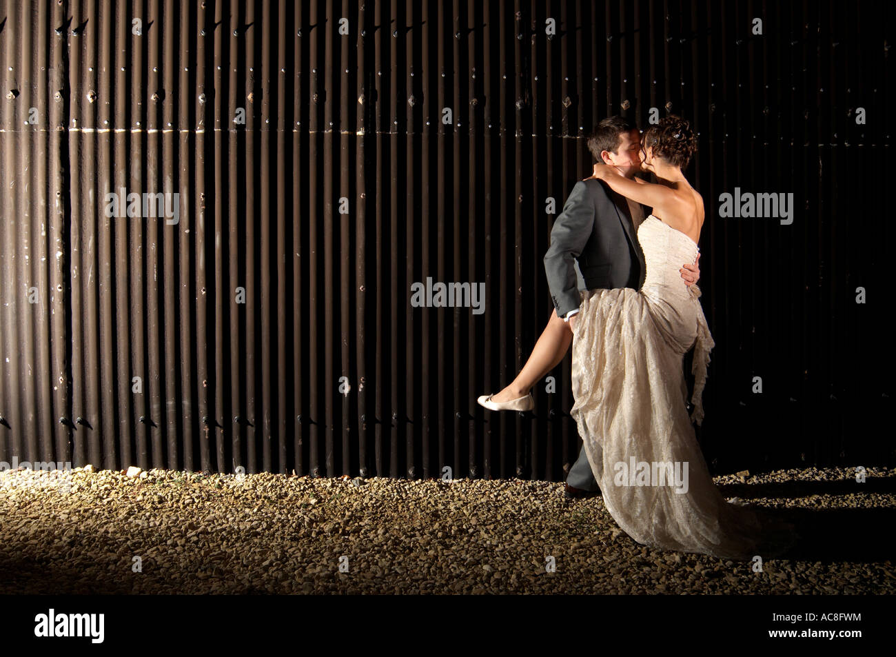 Contemporary Bride and Groom embracing and kissing with passion Stock Photo