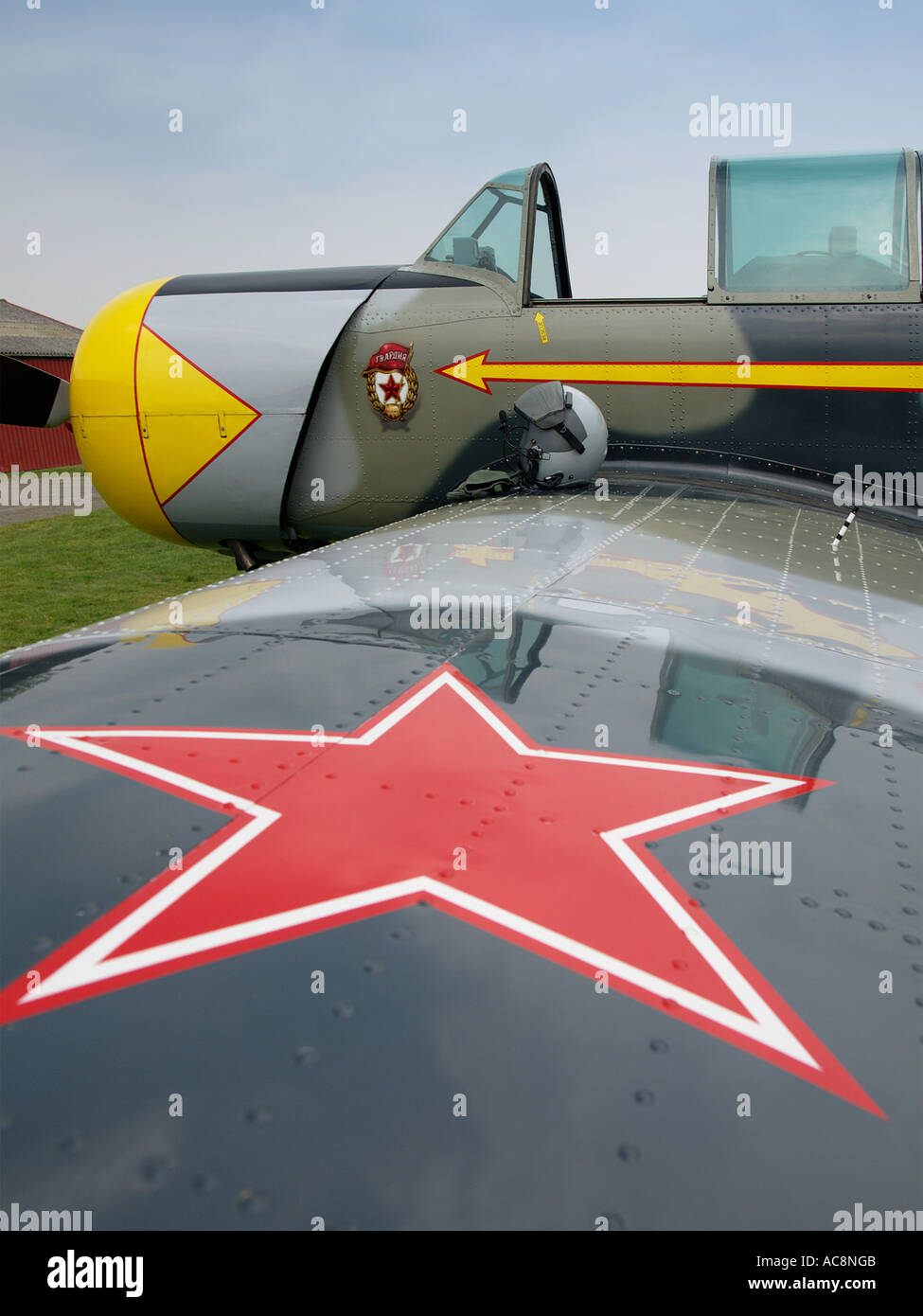 Yakovlev Yak 52 pilots helmet sitting on Yak 52 wing with big red star in the foreground Stock Photo