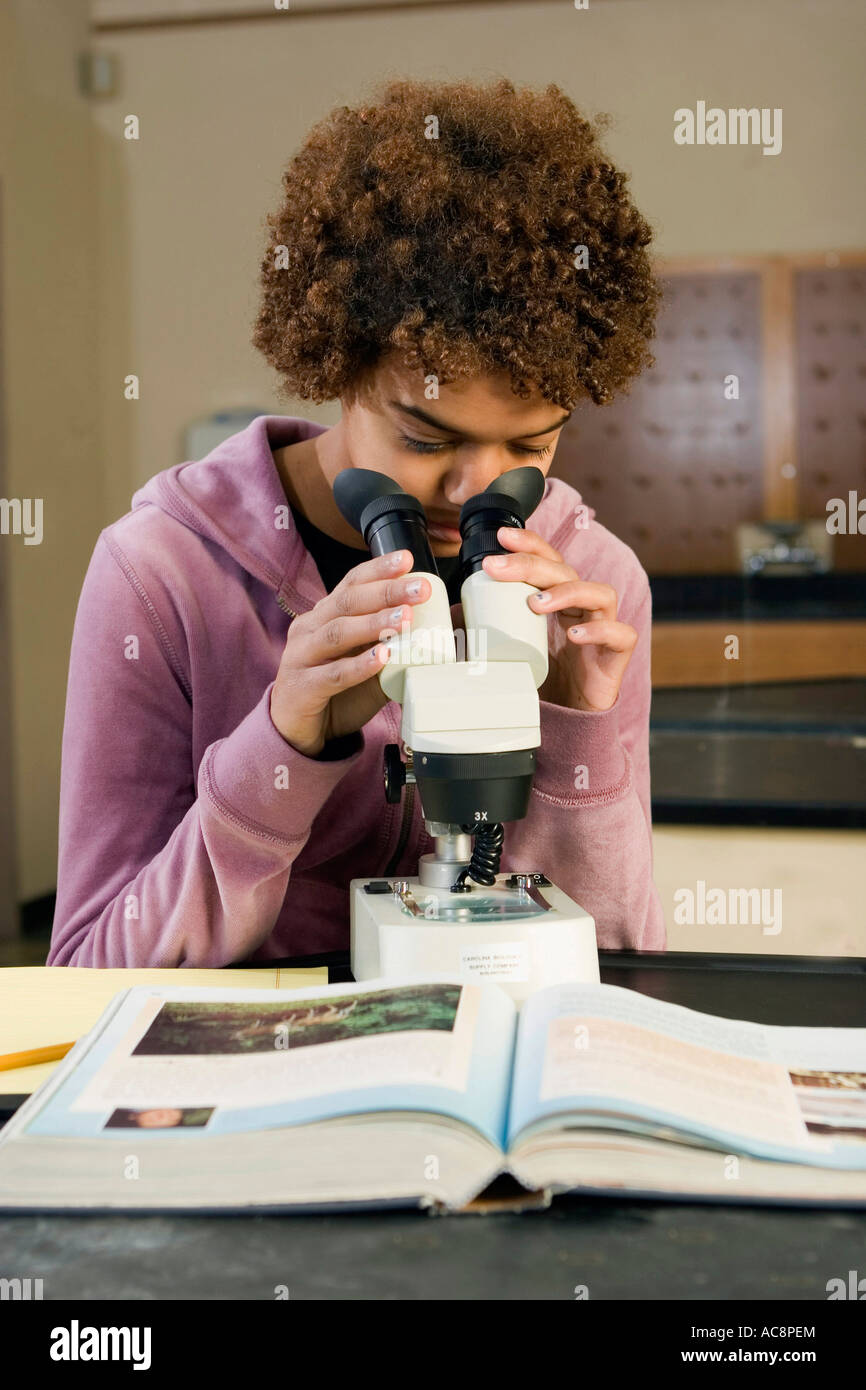 Student looking through a microscope in a science lab Stock Photo - Alamy