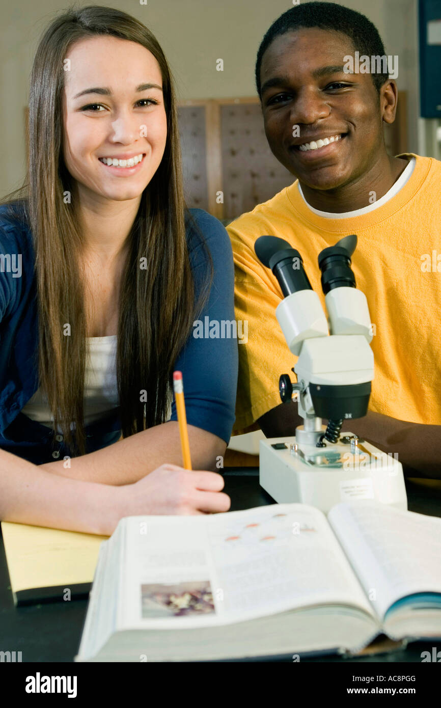 Two students in front of a microscope in a science lab Stock Photo - Alamy