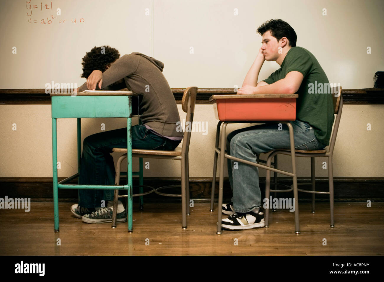 Two students sitting at desks in a classroom Stock Photo