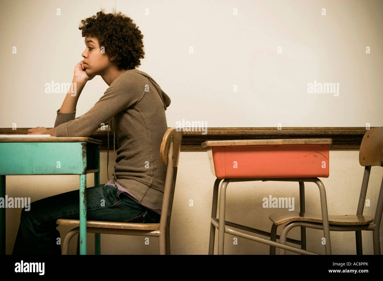 Student sitting at a desk in a classroom Stock Photo - Alamy