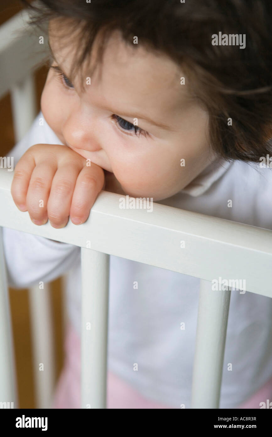 Closeup of a baby girl biting her hand in a crib Stock Photo Alamy