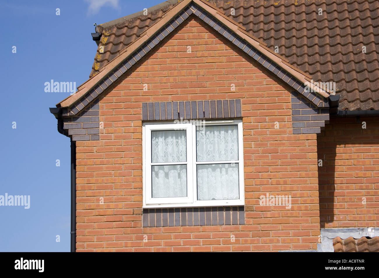 gable end of red brick house showing corbelling and