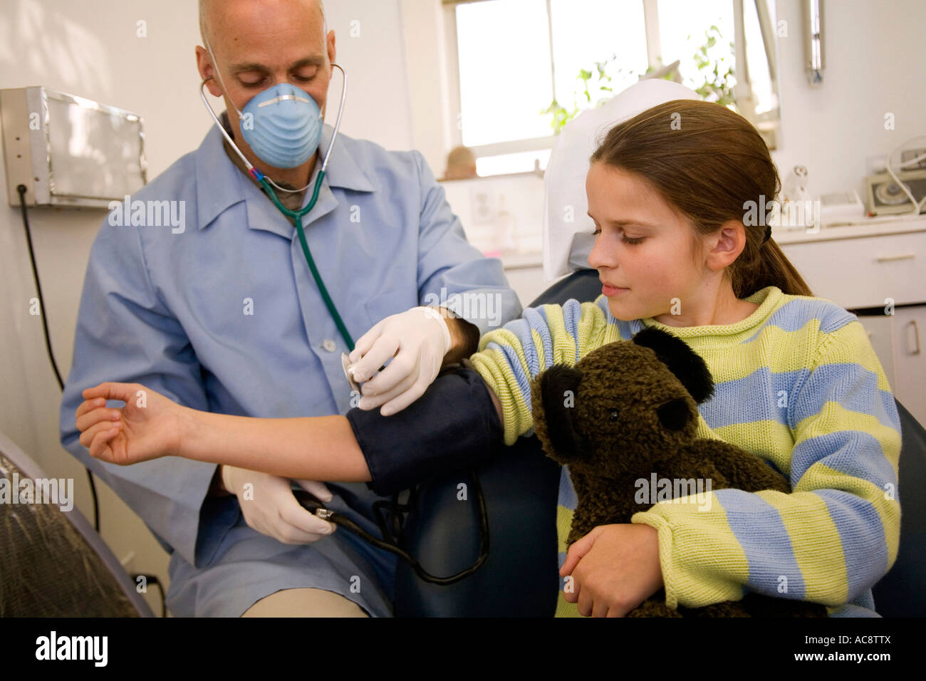 Male doctor checking the blood pressure of a patient Stock Photo