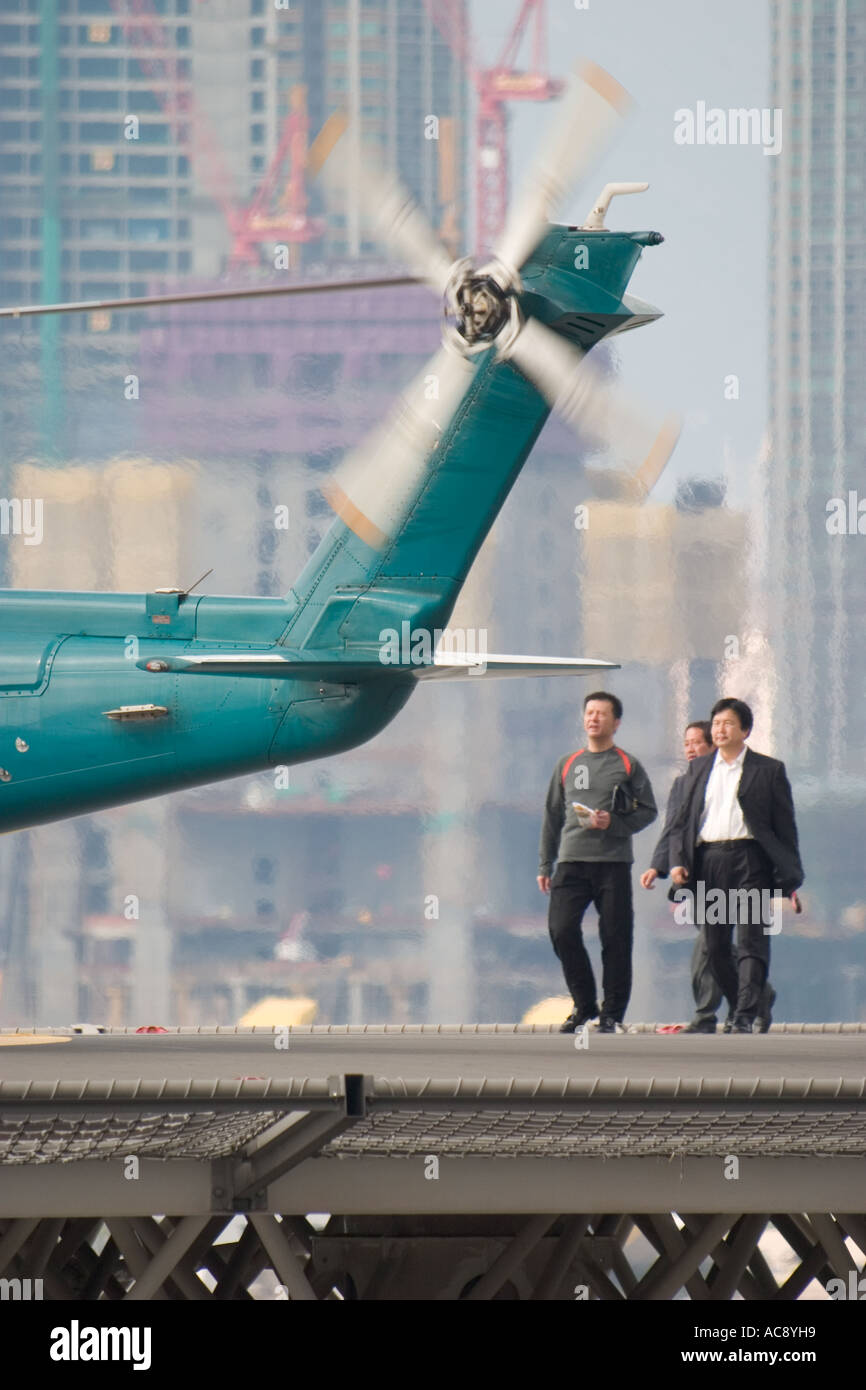 Businessman people walk toward helicopter to board Helijet Express at Shun Tak Heliport to Maca SAR Stock Photo