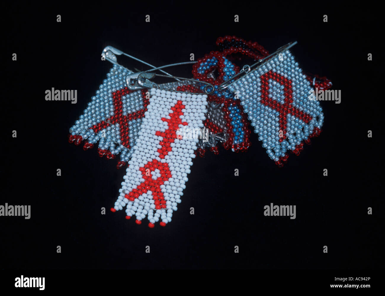 Beadwork brooches with the Aids and Tuberculosis emblem for sale at a