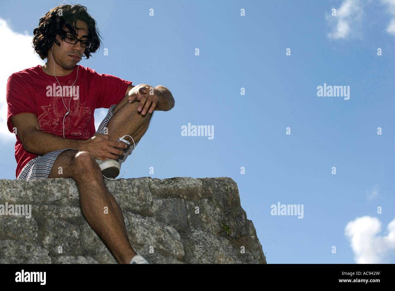 Low angle view of a young man listening to music Stock Photo