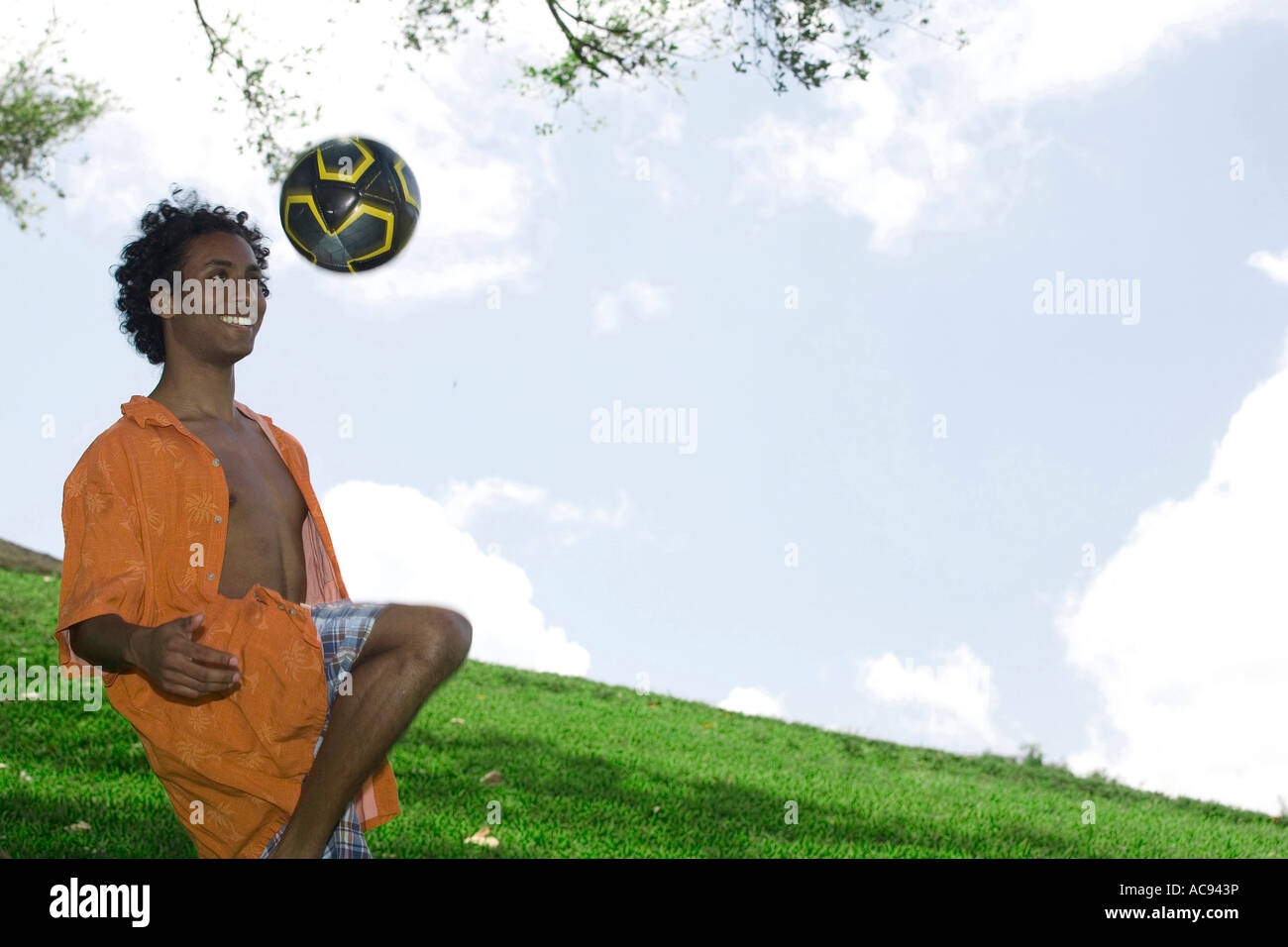 Young man kicking a soccer ball Stock Photo - Alamy