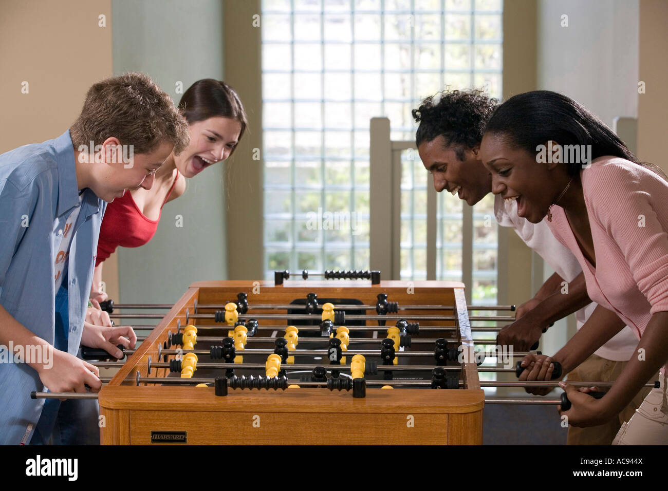Four people playing foosball Stock Photo Alamy