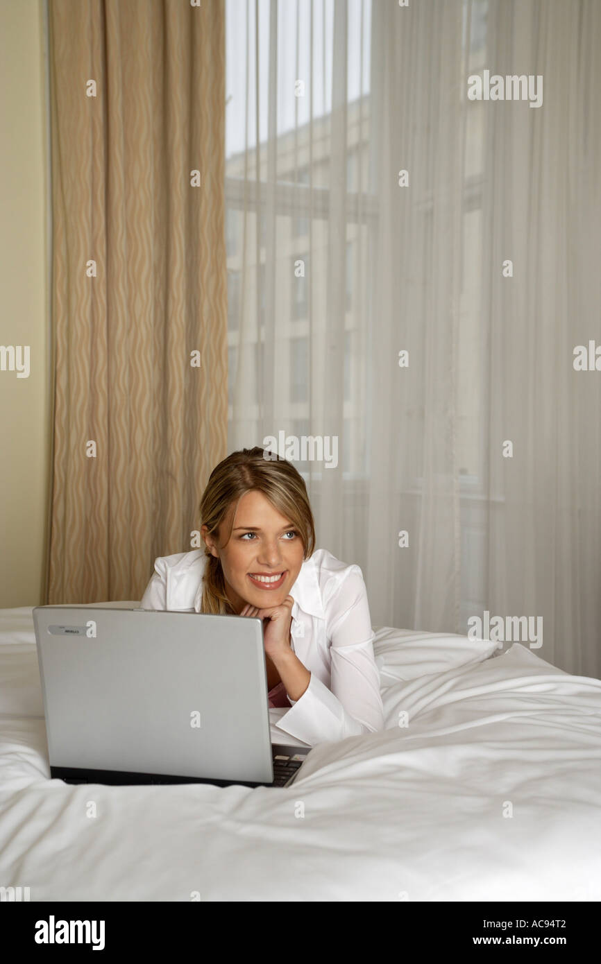 woman lying with laptop on bed Stock Photo - Alamy