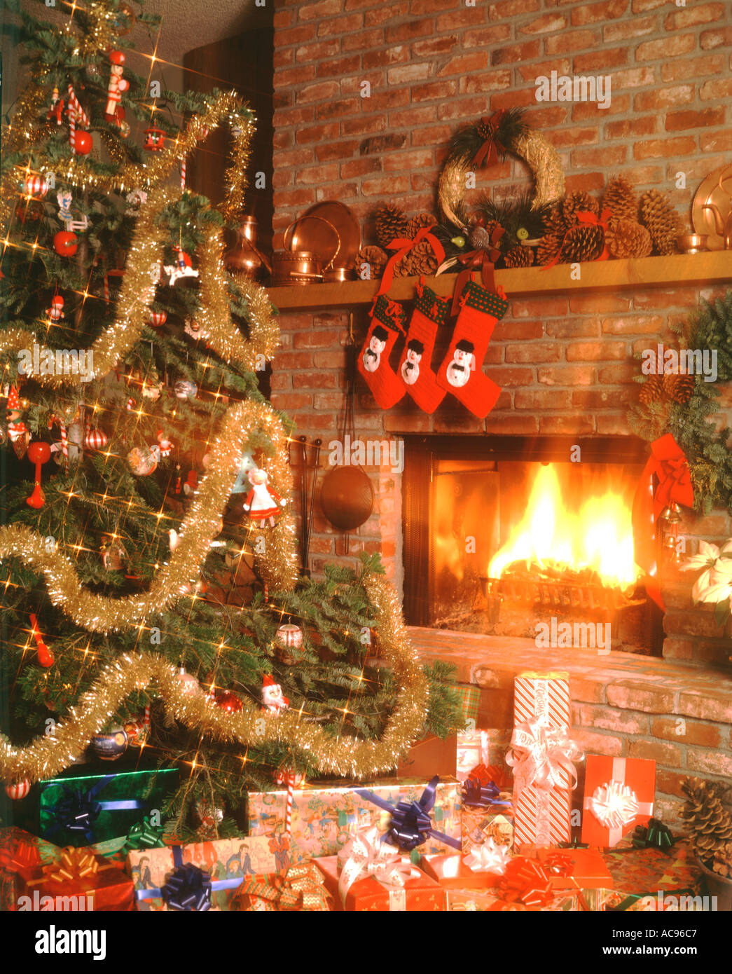 Christmas still life showing a decorated Christmas tree with presents in front of a blazing fireplace Stock Photo