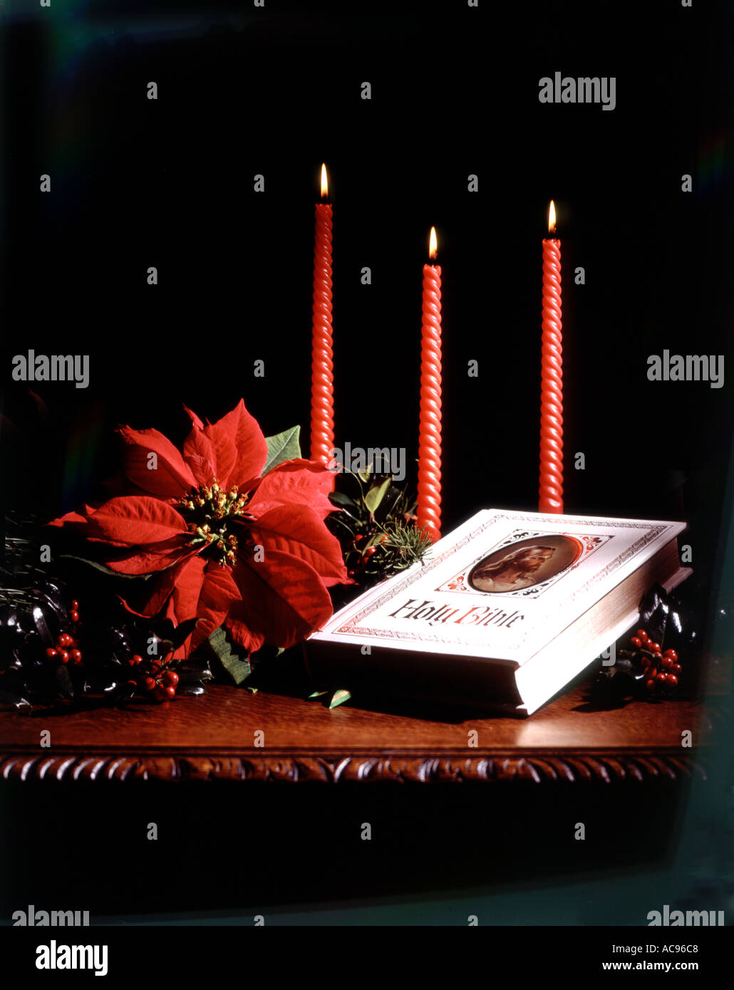 RELIGIOUS CHRISTMAS STILL LIFE WITH BIBLE CANDLES AND POINSETTIA PLANT ON  ANTIQUE CARVED WOOD TABLE Stock Photo - Alamy
