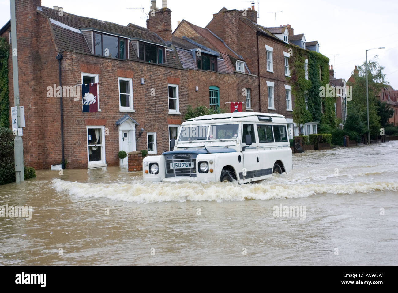 Landrover driving along flooded road near Tewkesbury Abbey Gloucestershire UK Stock Photo