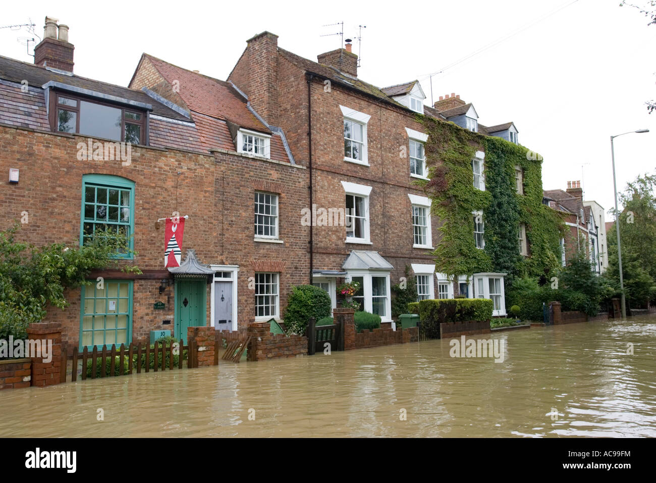 Flooded road and houses opposite Tewkesbury Abbey Gloucestershire UK Stock Photo