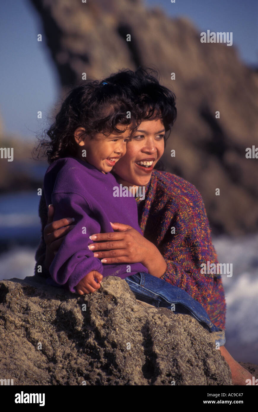 interracial multicultural multi racial Asian American Filipina woman  3-4 year years old little girl rock looking off onto distance  POV Stock Photo