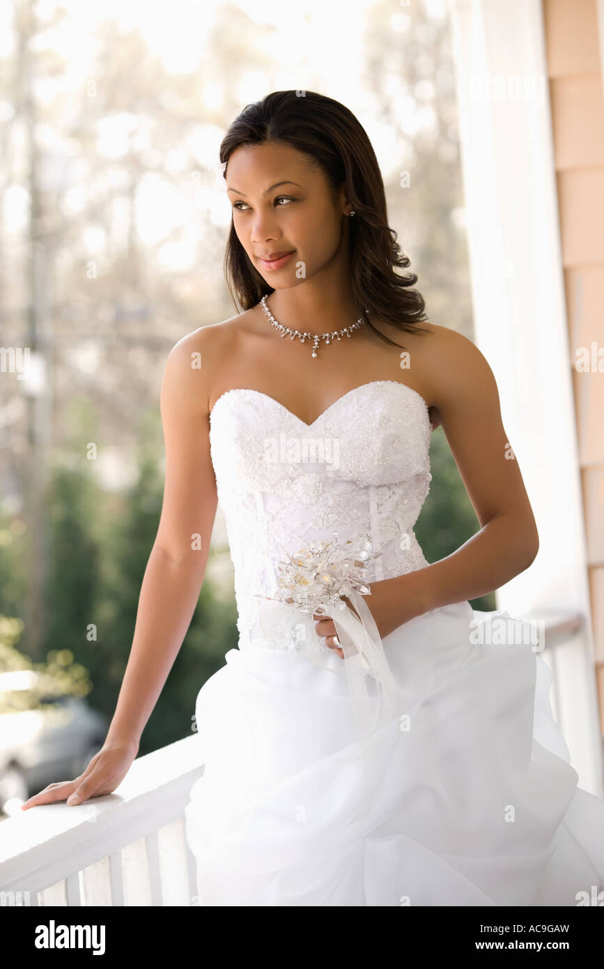 Portrait Of African American Bride Leaning Against Railing Stock