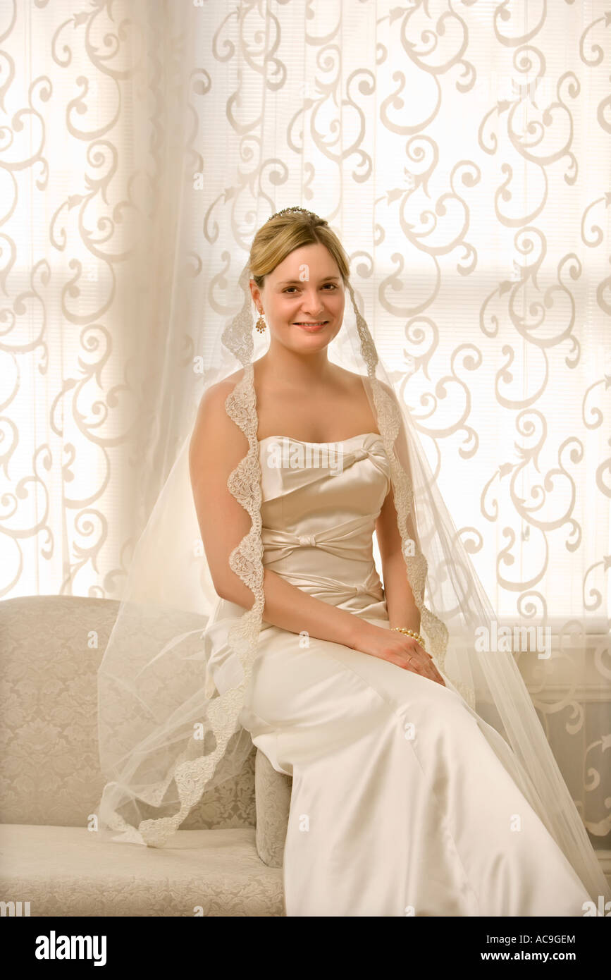 Portrait of Caucasian bride sitting on love seat Stock Photo - Alamy