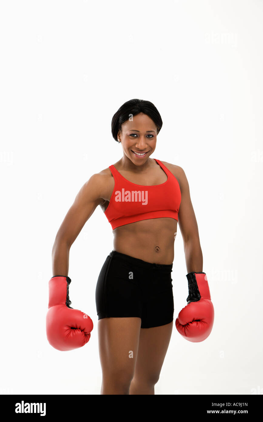 African American young adult woman wearing boxing goves smiling at viewer Stock Photo