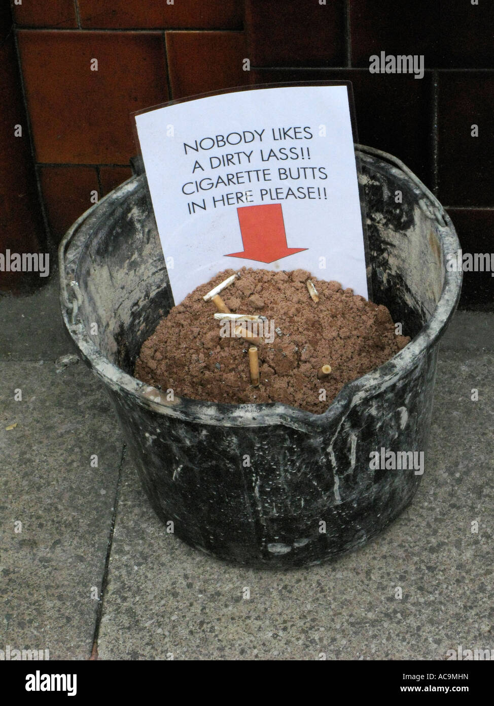 sand bucket outside a pub for used cigarette butts outside public house