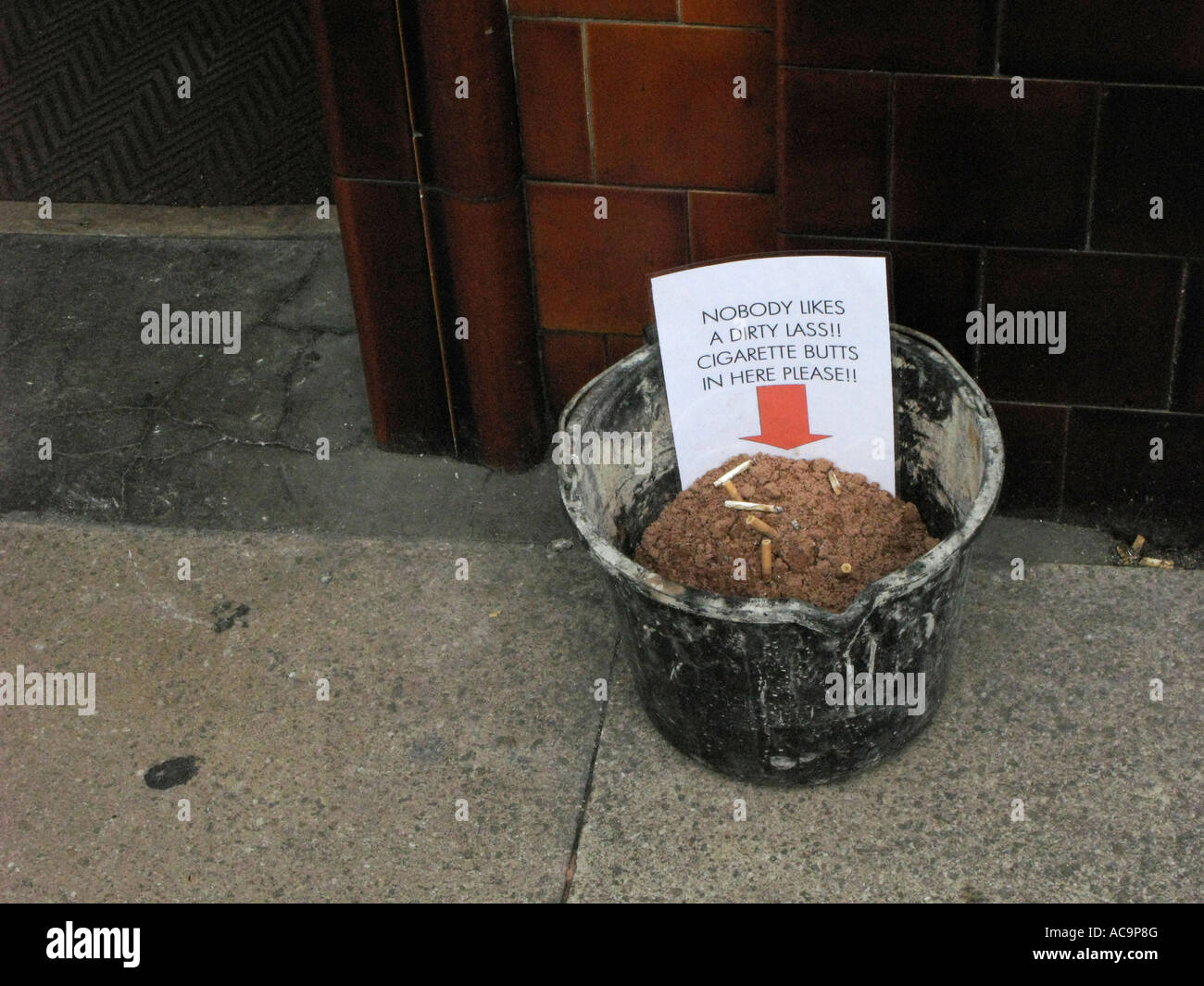 sand bucket outside a pub for used cigarette butts outside public house