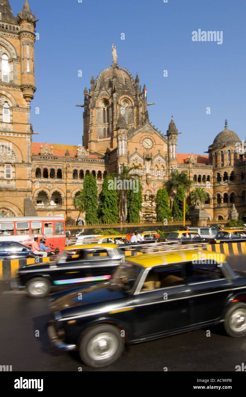 The Victoria Terminus with rush hour traffic travelling past in particular the traditional black and yellow taxis of Mumbai. Stock Photo