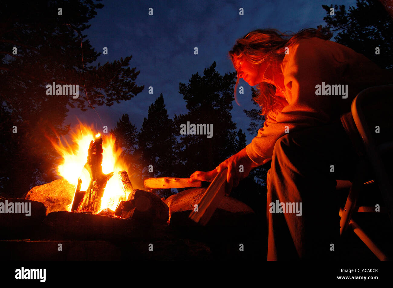Woman raking a fire Stock Photo Alamy