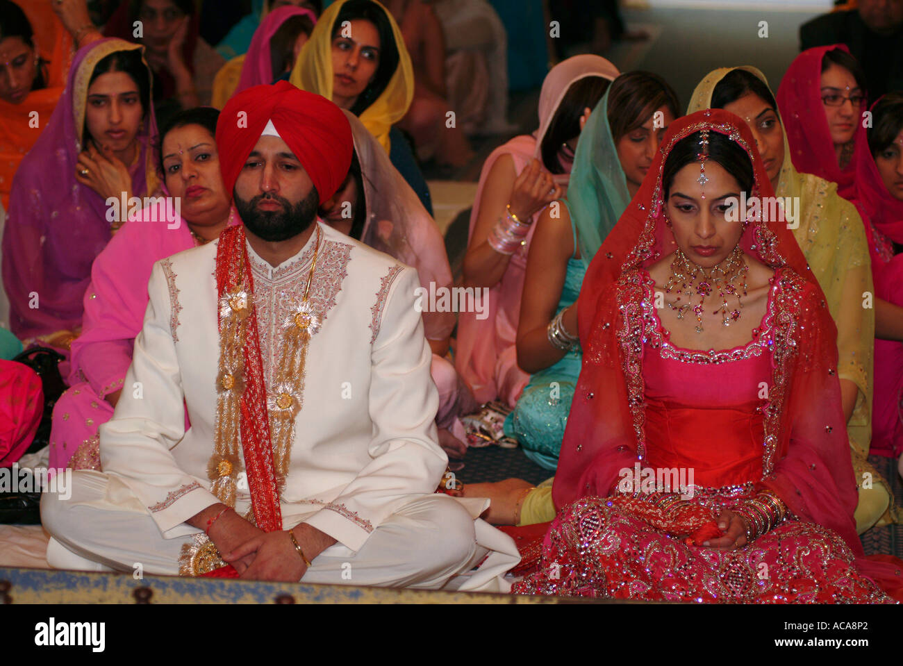 Sikh man and woman during marriage ceremony in temple or gurdwara Stock