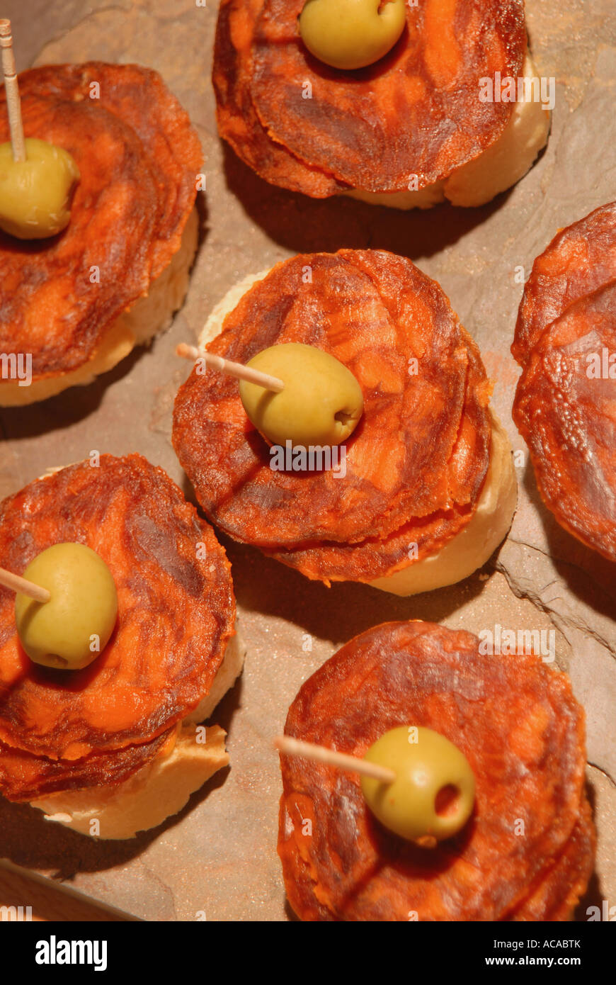 SPAIN. Tapa of chorizo Iberico de Bellota and stuffed olives on bread Stock Photo