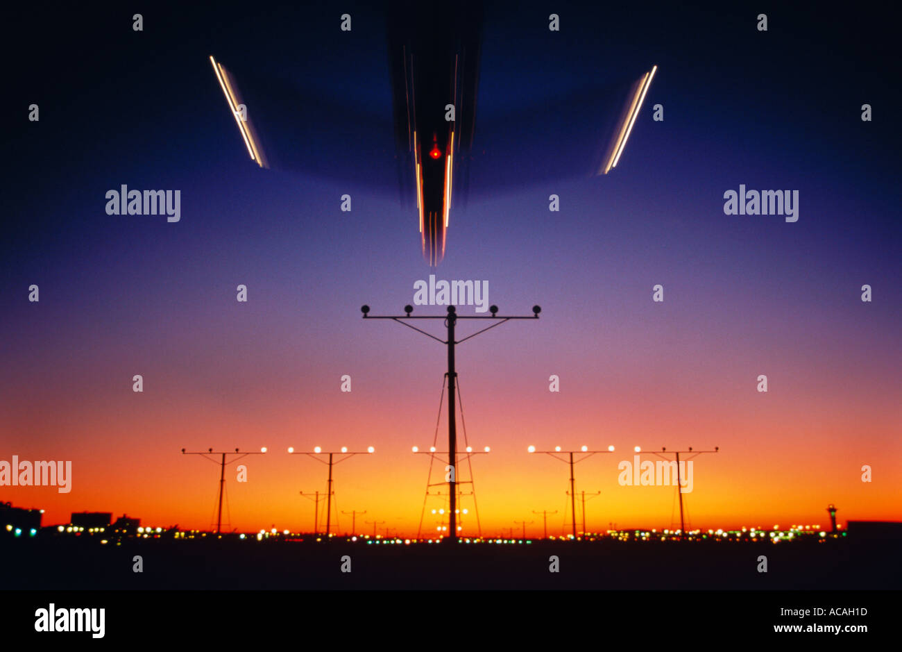 airliner landing over runway approach lights at night dusk sunset sunrise Stock Photo
