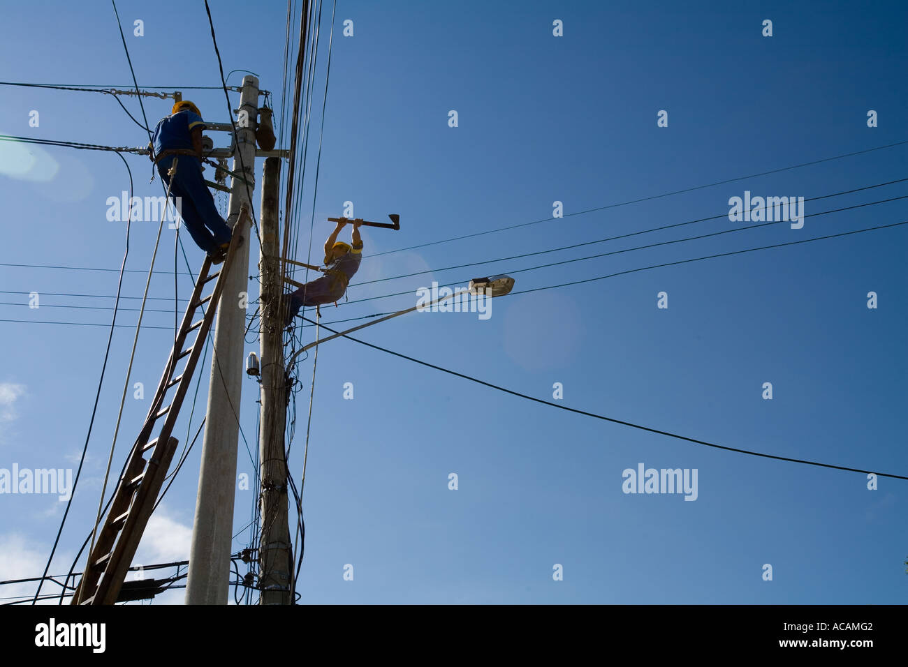 Engineer work a man is cutting down an electricity post with an axe Paraty Rio de Janeiro state Brazil Stock Photo