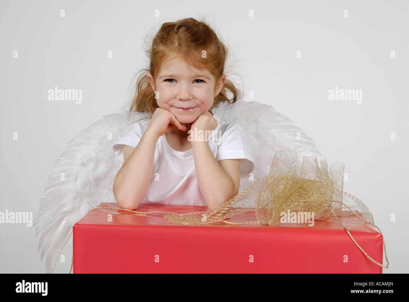 Little christmas angel with a christmas present Stock Photo